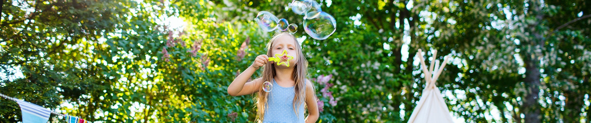 bambina che soffia le bolle di sapone
